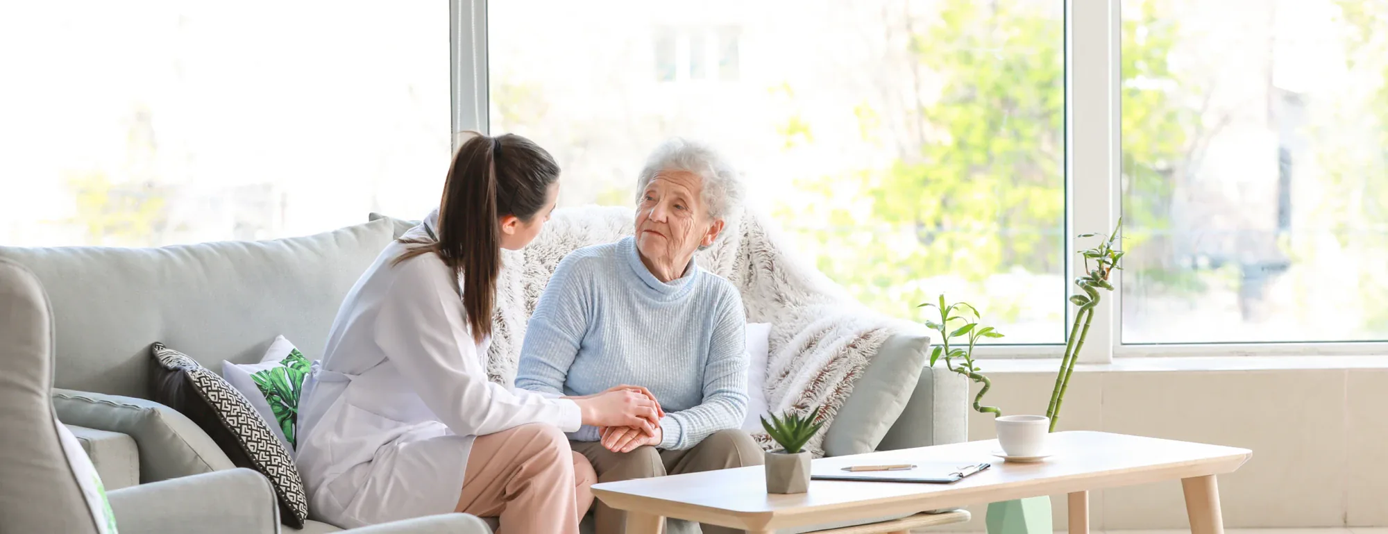 Pflegekraft im vertrauensvollen Gespräch mit einer Seniorin