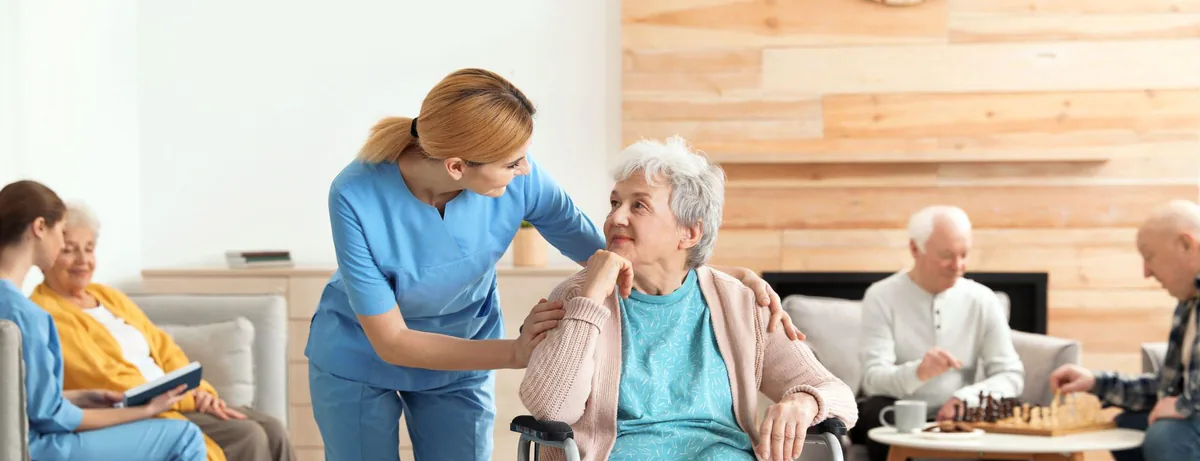 Pflegerin kümmert sich um eine Seniorin im Rollstuhl
