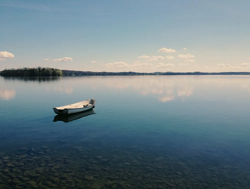 Ruderboot auf einem stillen See – Symbolbild für die Seenlandschaft rund um Plön
